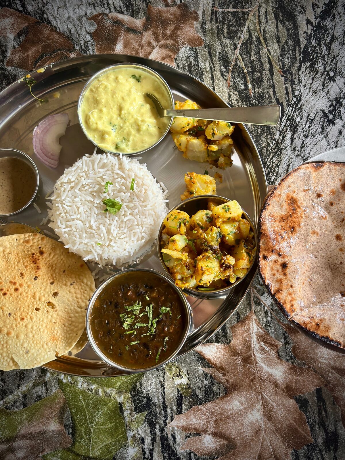 Stock photo: a full vegetarian thali with roti, rice, dal, and sabzi